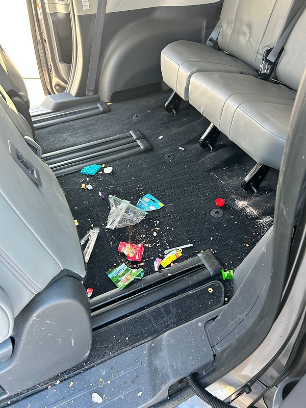 Before: snack wrappers, a plastic bag and crumbs across the back-row carpet of a minivan