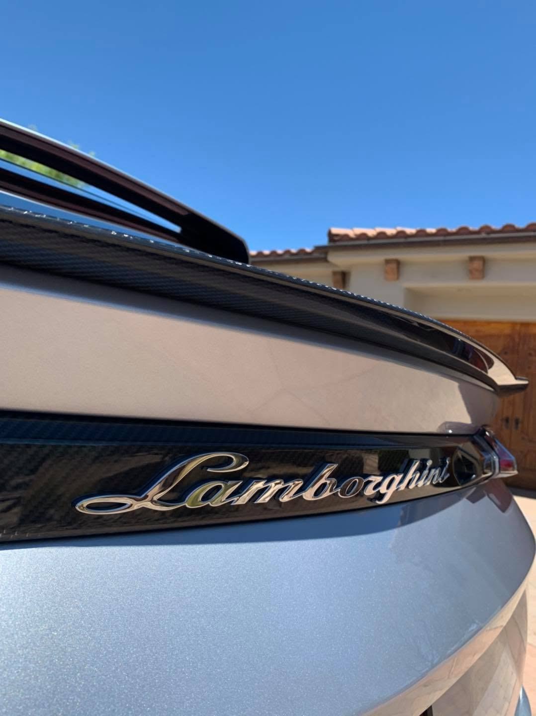 The polished flank and chrome lettering of a boat detailed on its trailer