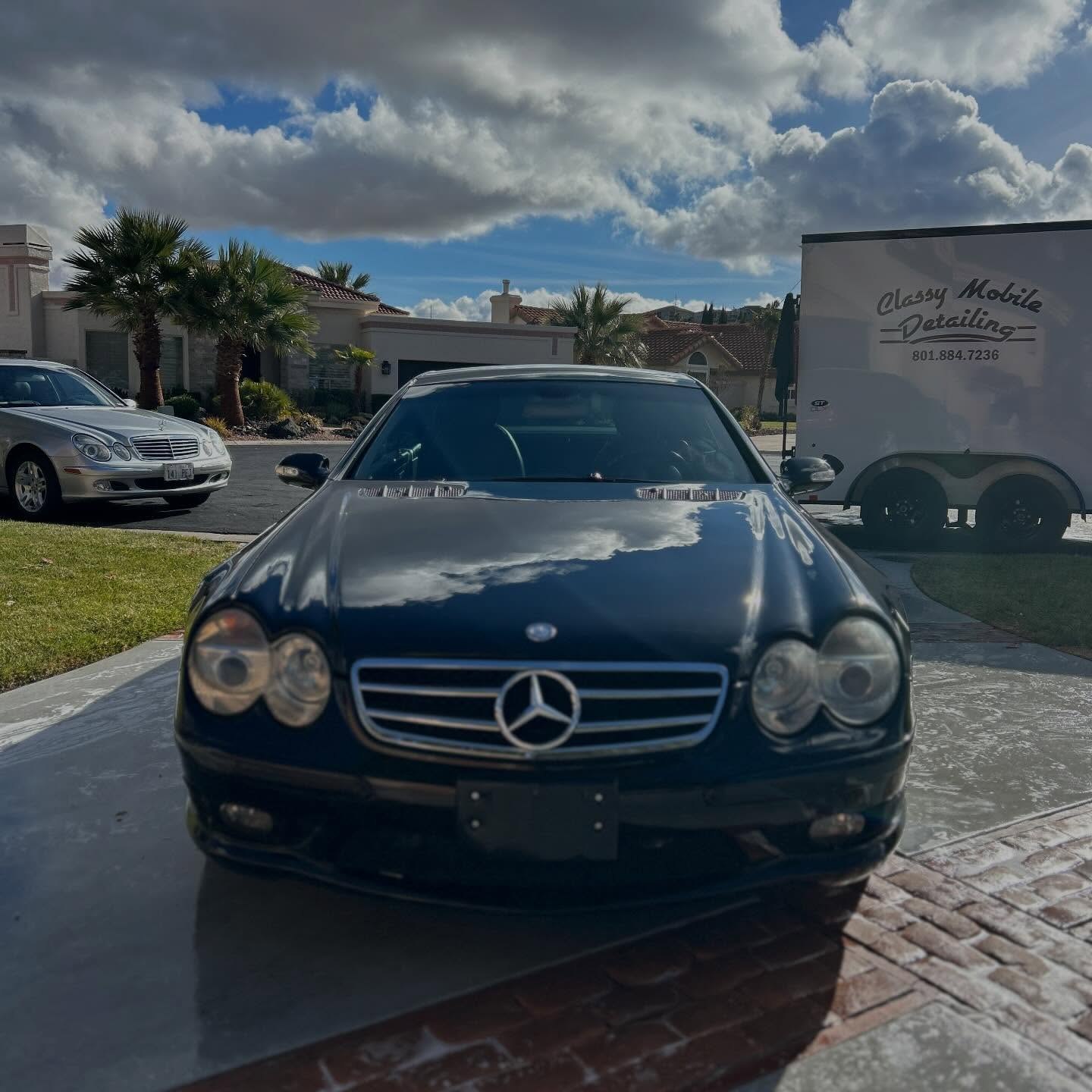 A black Mercedes coupe polished to a mirror finish, the Classy Mobile trailer parked behind